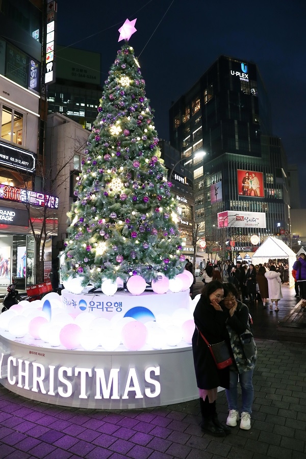시민들이 지난 21일 오후 서울 신촌 연세로와 명물거리에 경관조명으로 조성된 크리스마스 거리에서 기념촬영을 하고 있다.(사진=뉴시스)