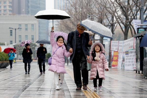 1일 오전 서울 종로구 광화문네거리 일대에서 어린이들이 할아버지와 함께 우산을 쓰고 걷고 있다. (사진=뉴시스)