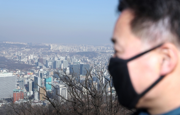 지난 5일 서울 남산에서 한 시민이 마스크를 쓰고 서울 도심을 바라보고 있다. (사진=뉴시스)