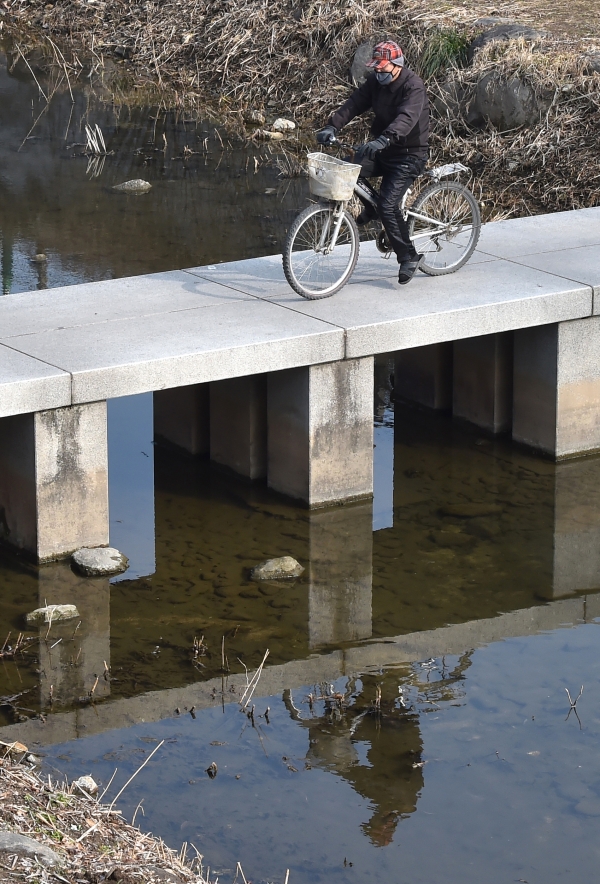 낮 최고기온이 14도까지 오르며 포근한 날씨를 보인 지난 14일 오후 경기 수원시 팔달구 수원 화성 화홍문 앞 수원천에서 한 시민이 자전거를 타고 있다. (사진=뉴시스)