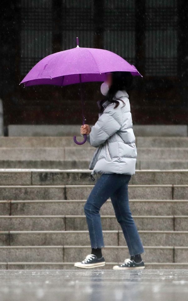 비가 내리는 지난 2월 25일 오전 서울 서대문구 독립문 공원에서 마스크를 착용한 시민이 우산을 쓰고 걸어가고 있다. (사진=뉴시스)