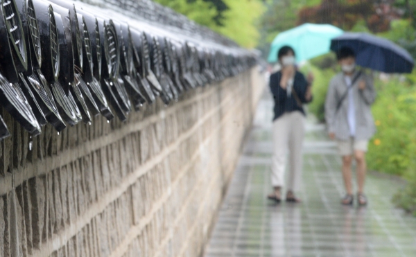 전북지역에 정체전선의 영향으로 비가 내린 29일 전북 전주시 전주한옥마을에서 우산을 쓴 관광객들이 발걸음을 재촉하고 있다. (사진=뉴시스)