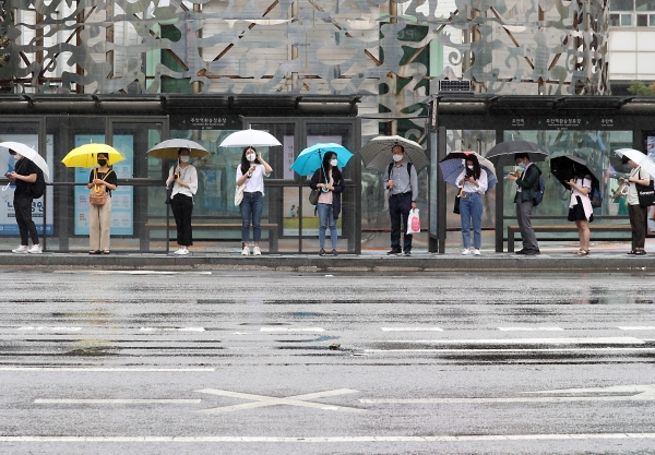 비가 오는 13일 오전 인천시 미추홀구 주안역 광장 버스정류장에서 시민들이 거리두기를 하면서 우산을 쓰고 버스를 기다리고 있다. (사진=뉴시스)