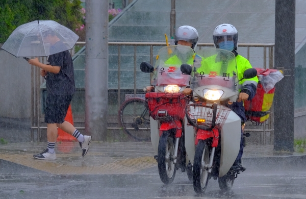 전국 곳곳에 비가 내린 13일 오후 인천시 서구청 근처 도로에서 우체국 집배원이 우편물 배달을 위해 빗속을 달리고 있다. (사진=뉴시스)