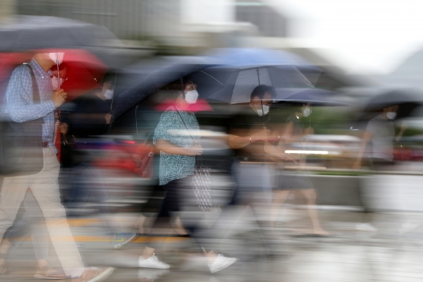 장맛비가 49일째 이어지고 있는 지난 11일 서울 종로구 광화문광장에서 시민들이 우산을 쓰고 출근하고 있다. (사진=뉴시스)