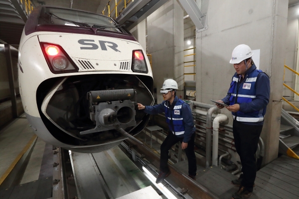 서울 수서역 SRT 정비소에서 직원들이 KT 5G 스마트안경을 이용해 열차를 정비하는 모습 (사진=KT 제공)