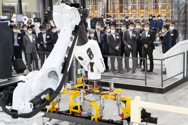 지난 19일 KT-현대중공업그룹 관계자들이 로봇물류시스템 데모센터에서 무인 자동화 솔루션이 적용된 기계를 보고 있다. (사진=KT 제공)