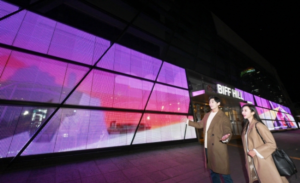 LG전자 모델들이 투명 LED 필름이 설치된 영화의전당 주변 경관을 소개하고 있다. (사진=LG전자 제공)