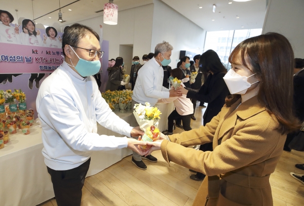 (사진 왼쪽부터)KT 구현모 대표와 최장복 노조위원장이 광화문에 위치한 KT 이스트 사옥에서 여성 임직원에게 꽃을 나눠주고 있다.  (사진=KT 제공)