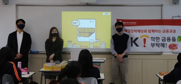 지난 18일 서울 선일여자중학교에서 박소희 OK저축은행 금융소비자보호부 사원(앞줄 가운데) 및 OK생활장학생들이 교육을 진행하고 있다. (사진=OK배정장학재단)