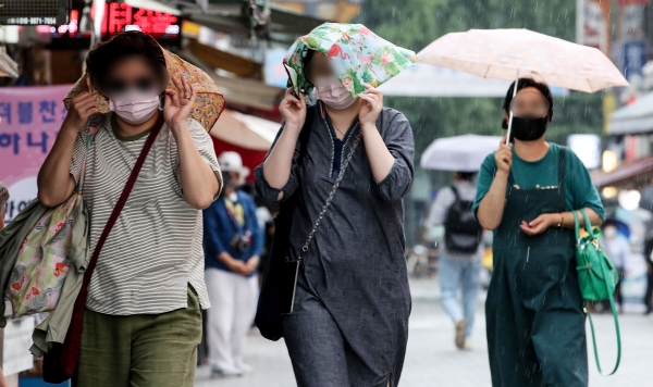 소나기가 내린 23일 오후 서울 중구 남대문시장에서 시민들이 손수건을 이용해 비를 피하고 있다. (사진=뉴시스)