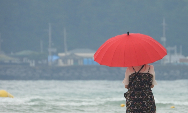 전국적으로 장맛비가 내리는 4일 오후 제주시 한림읍 금릉해수욕장을 찾은 관광객이 우산을 쓴 채 바다를 응시하고 있다.(사진=뉴시스)