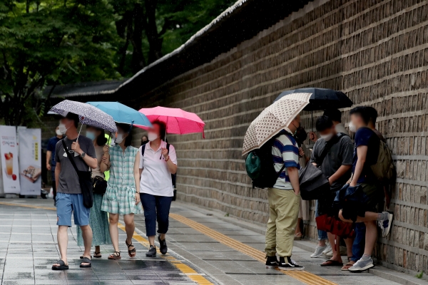 장마가 시작된 3일 오후 서울 중구 덕수궁 돌담길에서 시민들이 우산을 쓰고 있다.(사진=뉴시스)