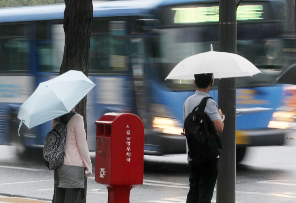 늦은 장맛비가 이어진 4일 오전 서울 중구 한국프레스센터 앞에서 우산을 쓴 시민들이 버스를 기다리고 있다. (사진=뉴시스)