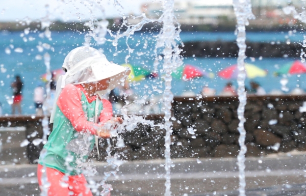 사실상 장마가 종료돼 무더운 날씨를 보이는 15일 오후 제주시 애월읍 곽지해수욕장 분수대에서 한 어린이가 물놀이를 하며 즐거운 시간을 보내고 있다.(사진=뉴시스)