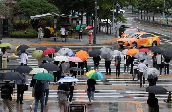 출근길 비가 내린 18일 오전 서울 용산역 앞 시민들이 횡단보도 신호를 기다리고 있다.(사진=뉴시스)