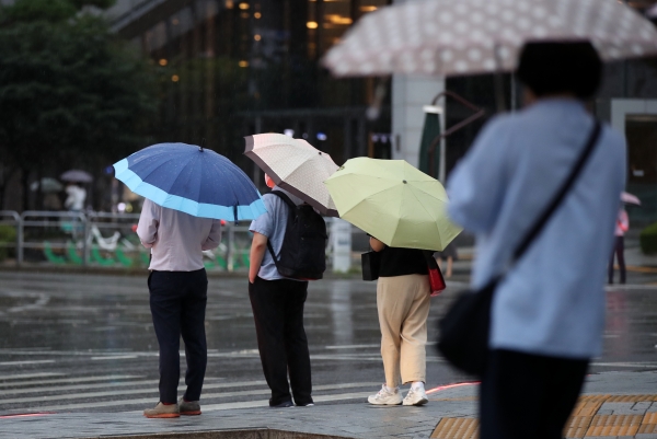 제12호 태풍 '오마이스'가 우리나라를 향해 북상하고 있는 23일 오후 서울 중구의 한 도로에서 시민들이 우산을 쓰고 지나가고 있다. (사진=뉴시스)