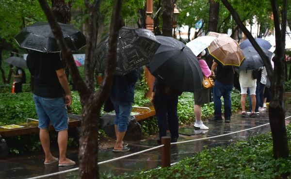 비가 내리고 있는 24일 대구 중구 국채보상운동기념공원 코로나19 임시선별검사소에서 시민들이 검사를 받기 위해 우산을 쓰고 긴 줄을 서고 있다.(사진=뉴시스)
