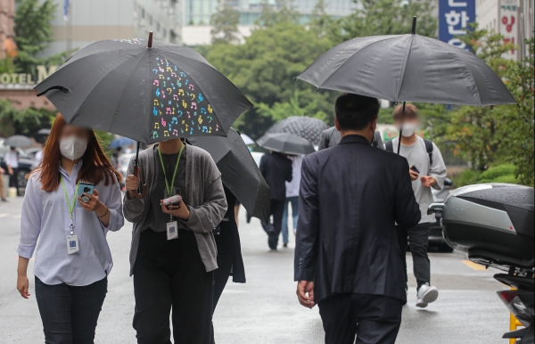 전국적으로 비가 내린 27일 오후 서울 여의도공원 인근에서 시민들이 우산을 쓰고 이동하고 있다.(사진=뉴시스)