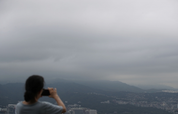 태풍 크로사가 만든 구름의 영향으로 전국에 흐린 날씨가 예상되는 16일 오전 서울 용산구 남산서울타워 전망대에서 한 시민이 하늘을 사진 찍고 있다. (사진=뉴시스)