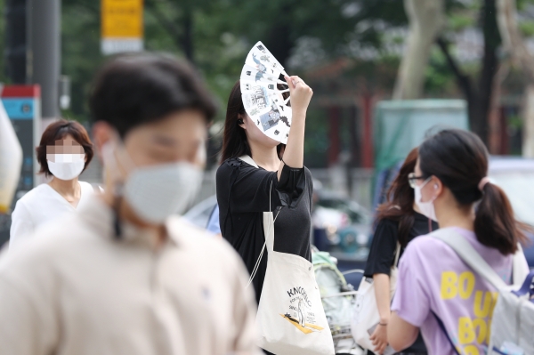 무더위가 이어지는 5일 오전 서울 종각역 인근에서 한 시민이 부채질을 하며 이동하고 있다. (사진=연합뉴스)