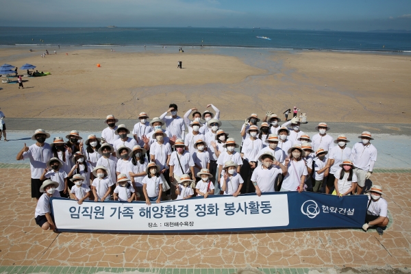 한화건설 임직원 가족들이 대천해수욕장 해양환경 정화 봉사활동에 참여하고 기념사진을 촬영하고 있다. (사진=한화건설)