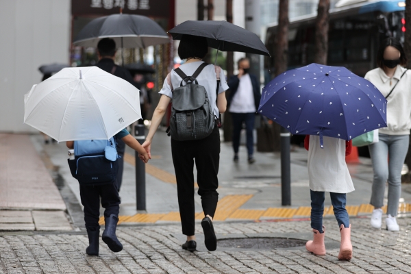비가 내리며 아침기온이 21도까지 떨어진 8월 29일 오전 우산을 쓴 어린이들이 서울 중구 을지로입구역 인근에서 엄마 손을 잡고 걷고 있다 (사진=연합뉴스)