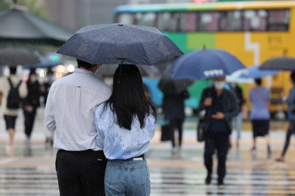 가을비가 내린 8월 30일 서울 광화문사거리에서 긴팔옷을 입은 시민들이 우산을 쓴 채 이동하고 있다(사진=연합뉴스)