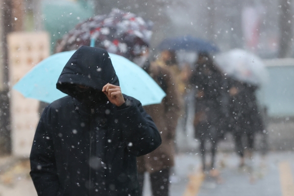 전국 곳곳 눈이 내린 13일 오후 서울지하철 여의도역 인근에서 모자를 쓴 시민이 이동하고 있다.(사진=연합뉴스)