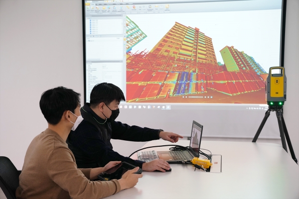 롯데건설 관계자가 3D 스캐너를 활용한 기존 아파트 모델링 데이터를 확인하고 있다. (사진=롯데건설)