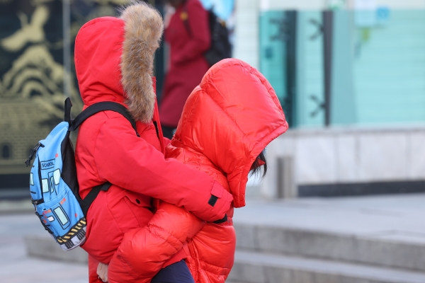 북서쪽에서 유입된 찬 공기로 아침 기온이 낮아진 20일 오전 서울 광화문네거리 인근에서 한 어린이가 엄마 등에 업혀 있다. (사진=연합뉴스)