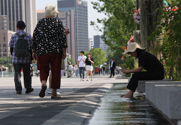 때이른 여름 날씨를 보이는 17일 오후 서울 광화문광장에서 한 시민이 수로에 발을 담그고 있다.(사진=연합뉴스)